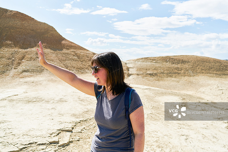 身穿休闲装、戴着太阳镜的女人在巴尔德纳斯雷亚莱斯做出停止手势，面带微笑看向远方图片素材