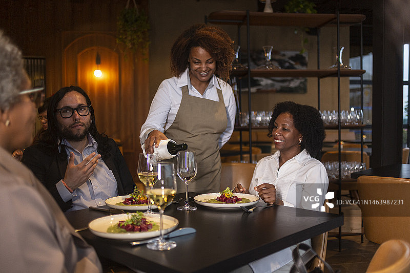 侍者为商务人士倒酒图片素材