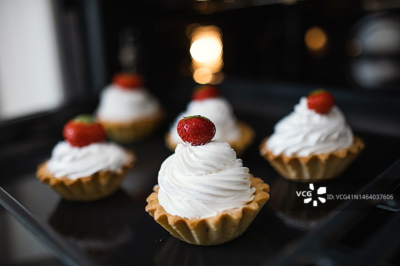烤箱里的奶油草莓纸杯蛋糕图片素材