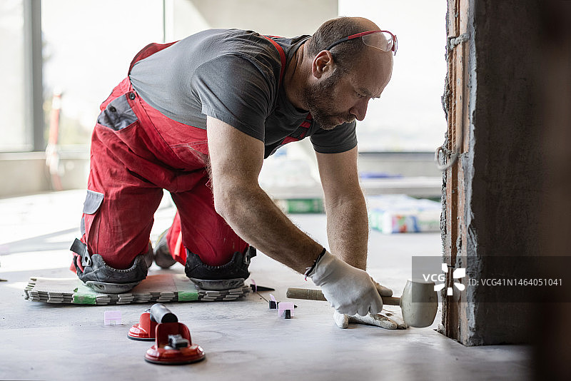 专业瓦工用橡胶锤安装瓷砖图片素材