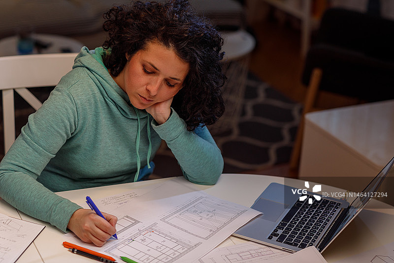 女室内设计师在家工作到很晚，修改室内设计方案图片素材