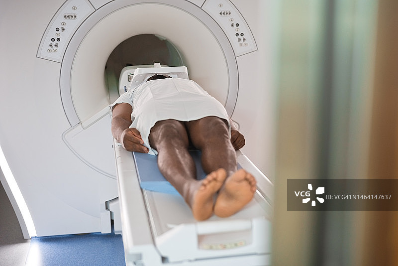 男病人躺在核磁共振扫描仪上接受检查图片素材