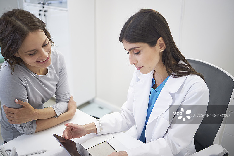医生与女性患者在诊所、医院讨论医疗保健问题图片素材