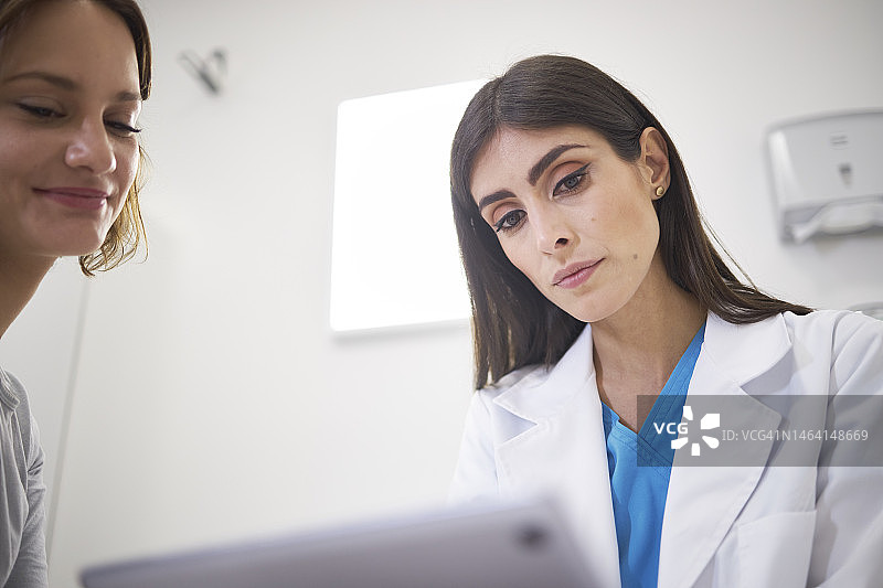 医生与女性患者在诊所、医院讨论医疗保健问题图片素材