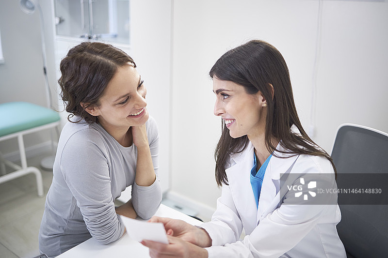 医生与女性患者在诊所、医院讨论医疗保健问题图片素材