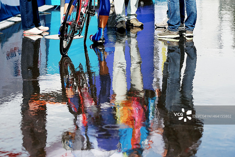 业余自行车手在雨水坑中的彩色倒影图片素材