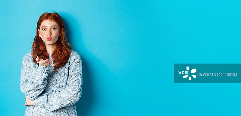 穿着毛衣，嘟着嘴，凝视着镜头的可爱少女图片素材