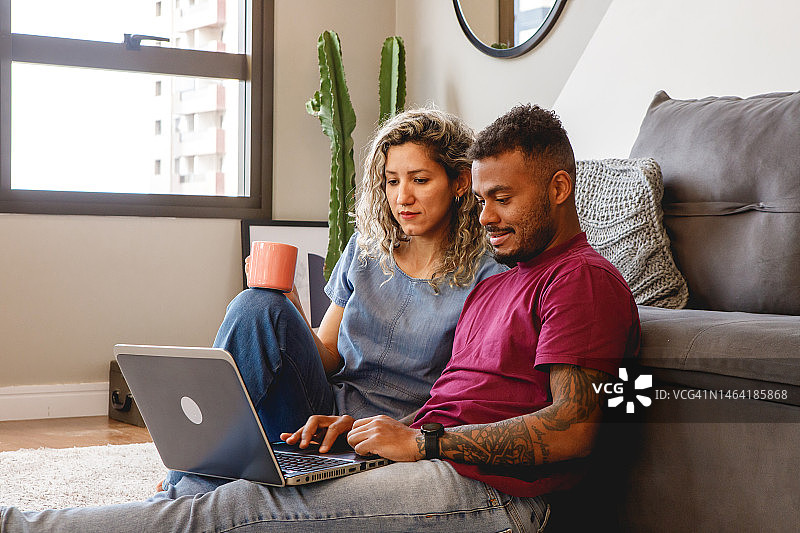 在沙发上放松，用笔记本电脑观看内容的夫妇图片素材