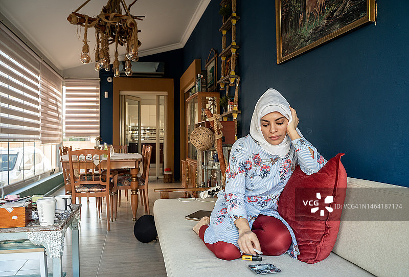 沮丧的阿拉伯穆斯林女人在家吸烟，不健康的生活方式概念，土耳其图片素材