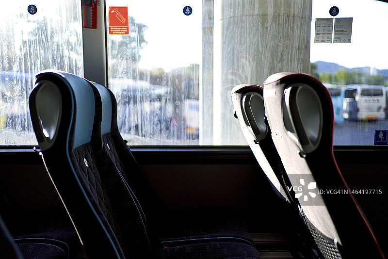 阳光下，空荡荡的公交车座位内部靠窗特写图片素材