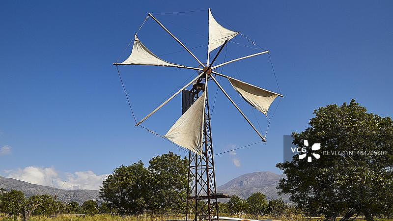 克里特岛拉西锡高原的风车，帆布，树木，蓝天，白云图片素材