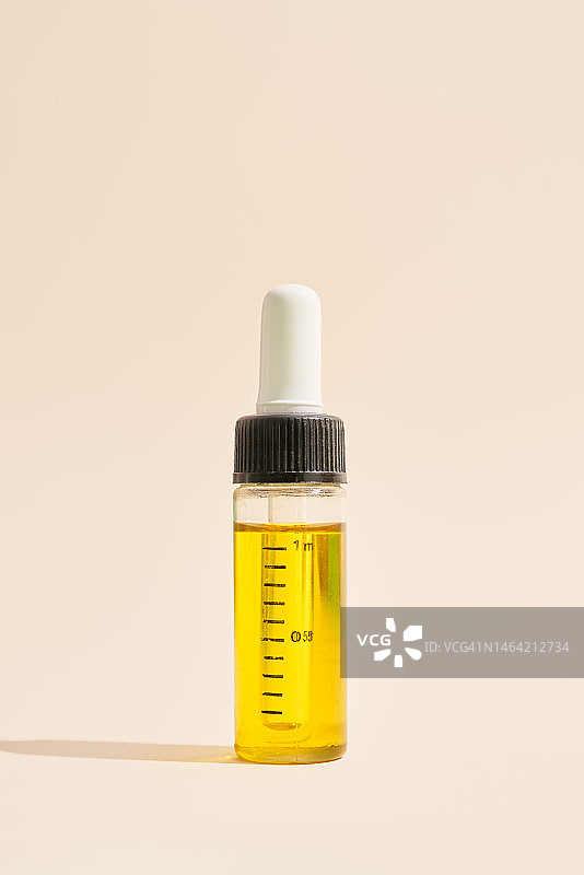 带滴管的精油滴管瓶与米色背景图片素材