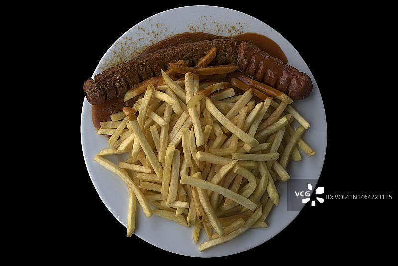 黑色背景上的咖喱香肠和炸薯条，德国巴伐利亚州图片素材