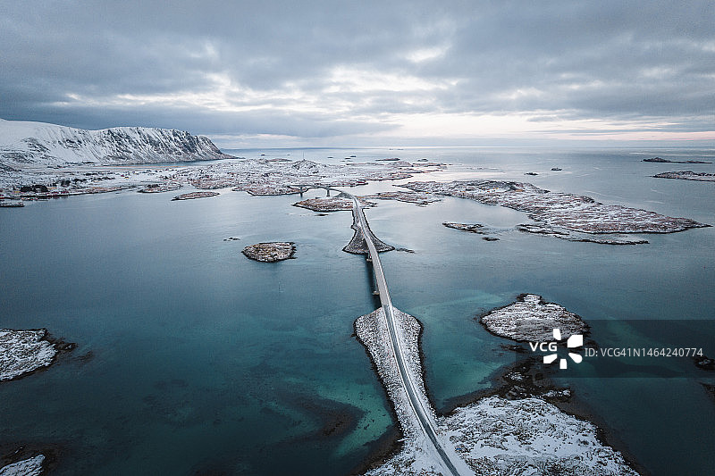 挪威罗弗敦群岛的冬季景观、雪山和冰冻道路鸟瞰图图片素材