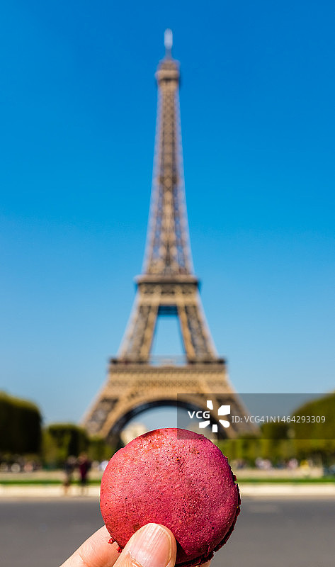 手持法式马卡龙，背景为巴黎埃菲尔铁塔图片素材