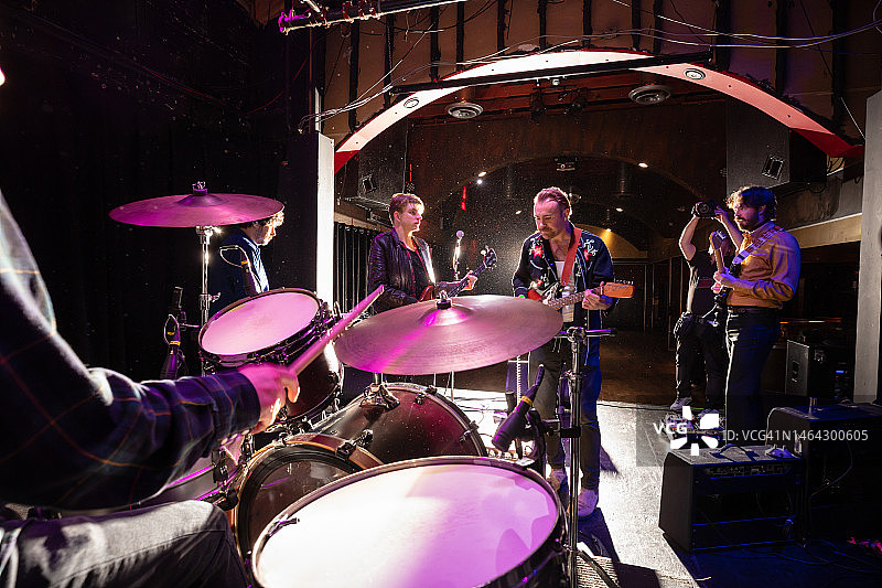 乐队在舞台上进行音响测试，摄影师正在拍照图片素材