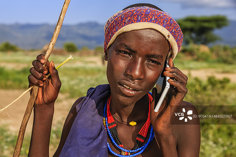 使用智能手机的埃塞俄比亚阿尔博雷部落男孩图片素材