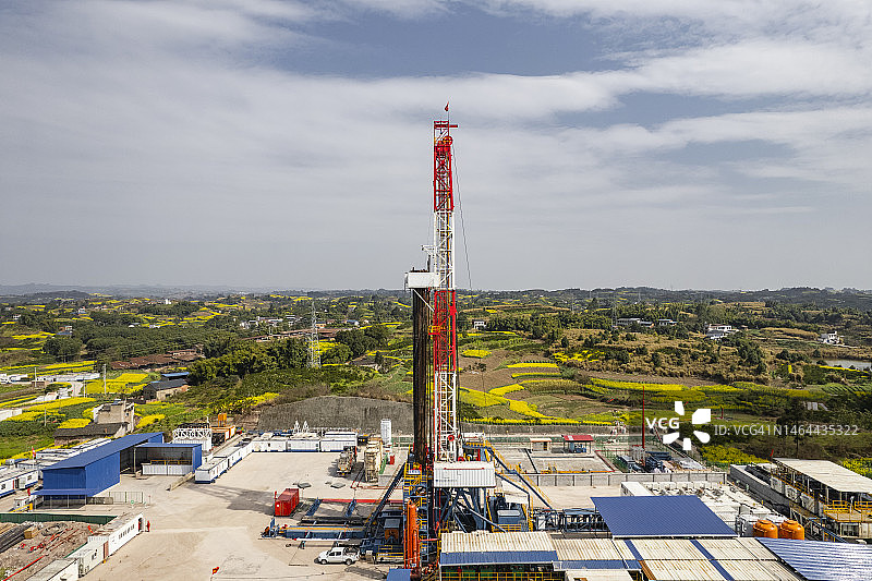 四川南部油菜花田中页岩气钻井现场航拍照片图片素材