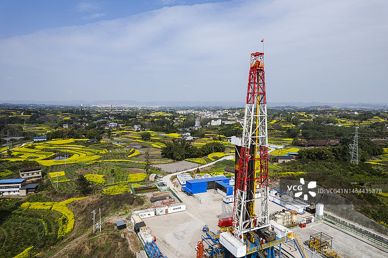 四川南部油菜花田中页岩气钻井现场航拍照片图片素材