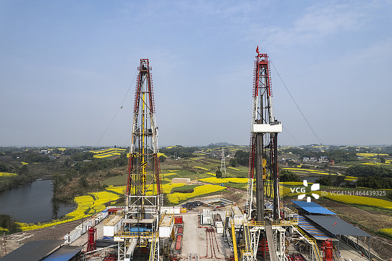 四川南部油菜花田中页岩气钻井现场航拍照片图片素材