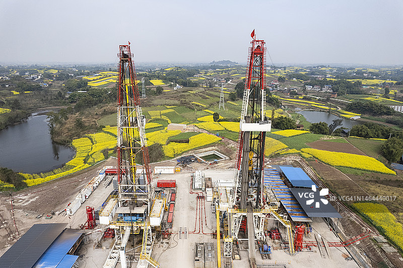 四川南部油菜花田中页岩气钻井现场航拍照片图片素材