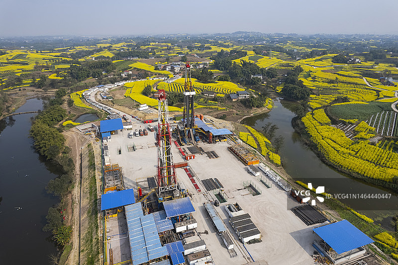 四川南部油菜花田中页岩气钻井现场航拍照片图片素材