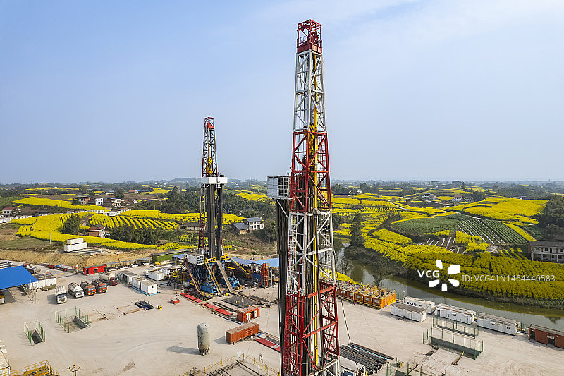 四川南部油菜花田中页岩气钻井现场航拍照片图片素材