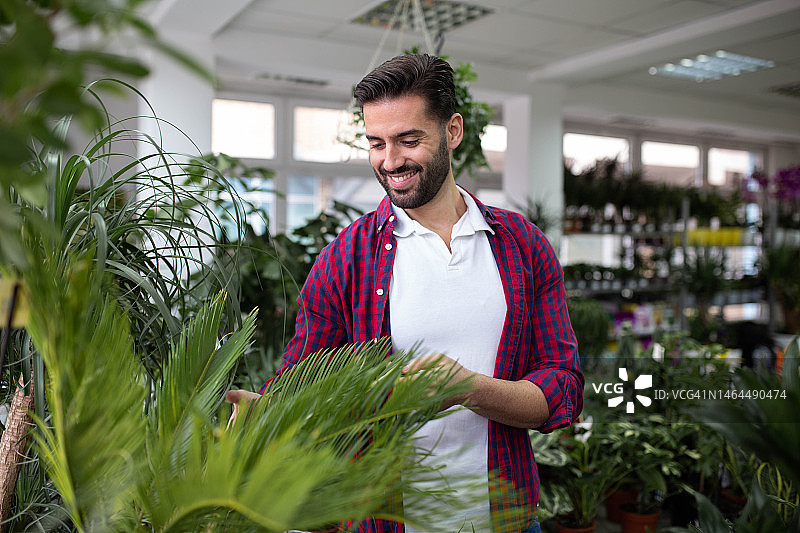 面带微笑的花匠在花园中心照料花朵图片素材