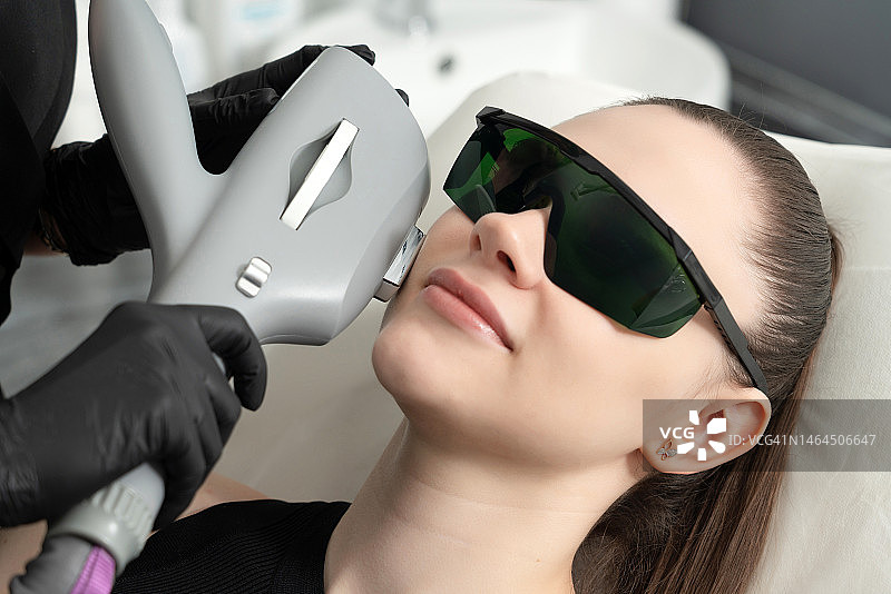 年轻女人在美容诊所接受激光治疗图片素材