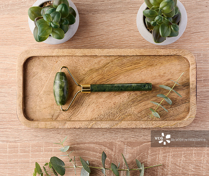 玉石面部按摩器，棕色木质背景上的化妆品，乌克兰图片素材