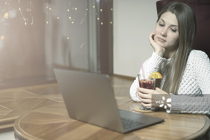 傍晚，年轻女孩在咖啡馆上网图片素材