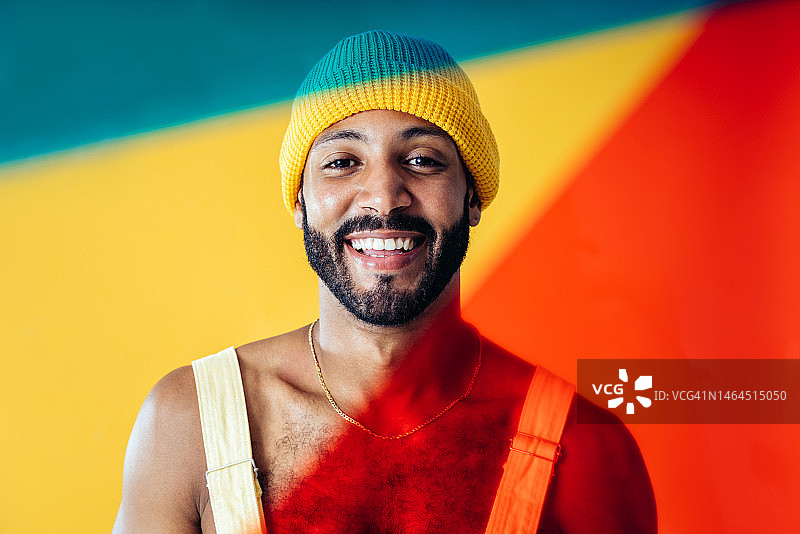 男人在西班牙巴塞罗那的彩色背景工作室穿着时尚的衣服摆姿势图片素材