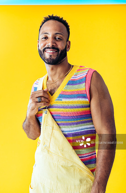 男人在西班牙巴塞罗那的彩色背景工作室穿着时尚的衣服摆姿势图片素材