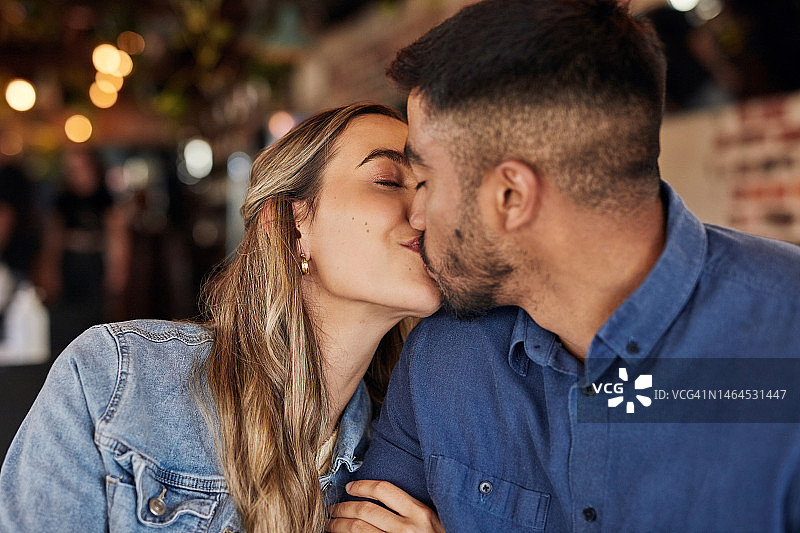 情侣在餐厅亲吻，享受美好情人节图片素材