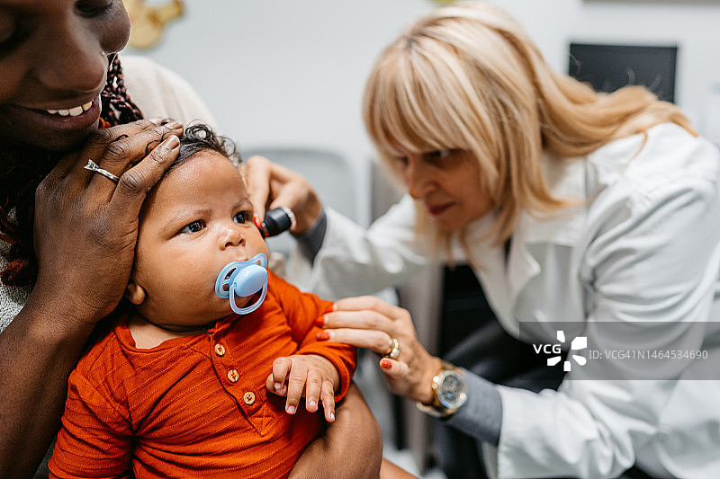 年轻女儿科医生检查新生男婴图片素材
