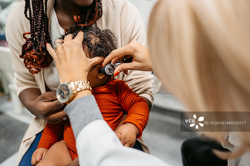 年轻女儿科医生检查新生男婴图片素材