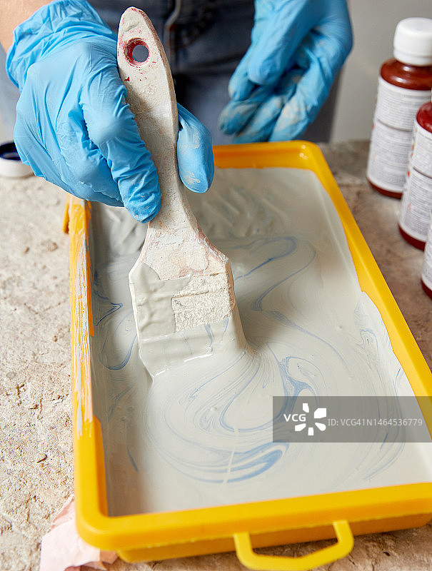 戴手套的手使用画笔和颜料图片素材