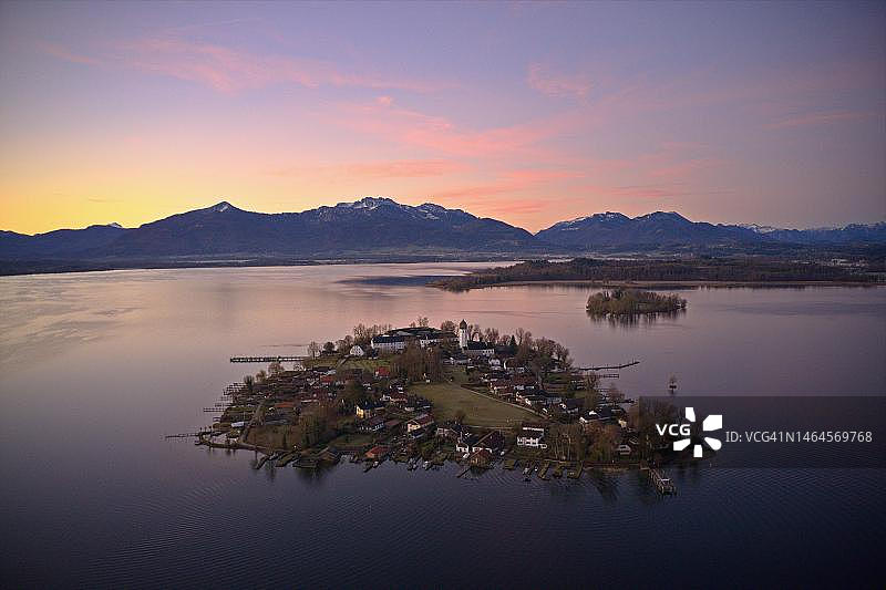 日出时从上方俯瞰基姆湖,前景是弗劳恩因塞尔,后面是海伦因塞尔和基姆高阿尔卑斯山,无人机照片,基姆高,巴伐利亚,德国图片素材