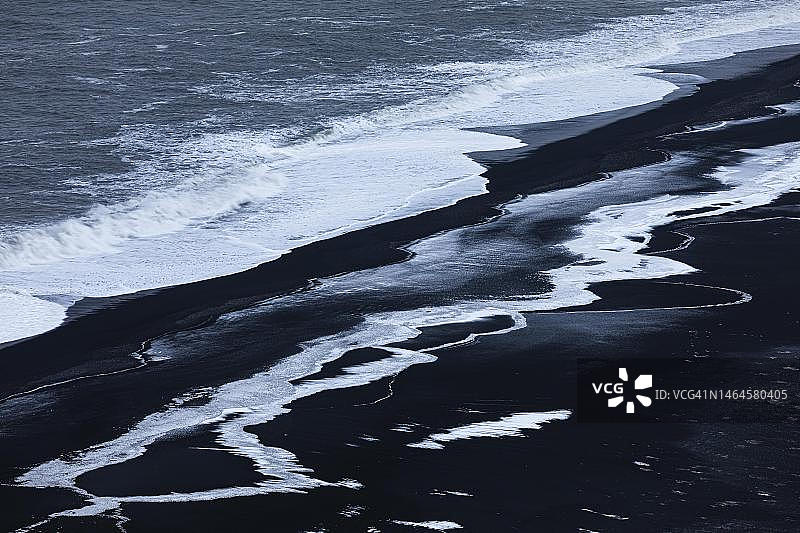 冰岛斯科加桑杜黑卵石海滩上的白色浪花图片素材