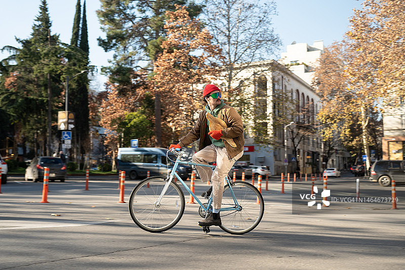 格鲁吉亚男子清晨骑自行车携带新鲜面包图片素材