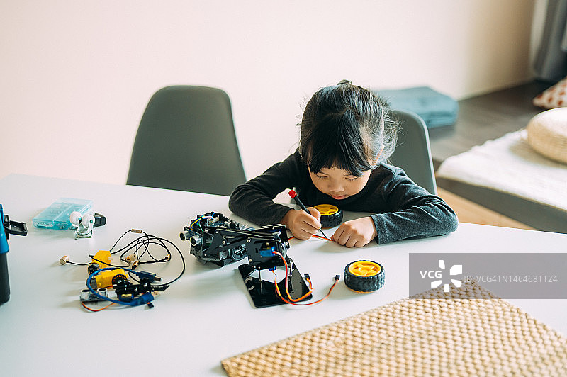 专心致志的亚洲女孩在实验室制作机器人图片素材