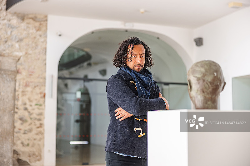 在博物馆观看男性头像雕像的黑人男子图片素材
