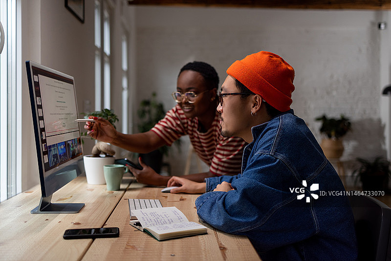 跨种族创意情侣在现代家庭办公室一起工作，进行项目头脑风暴图片素材