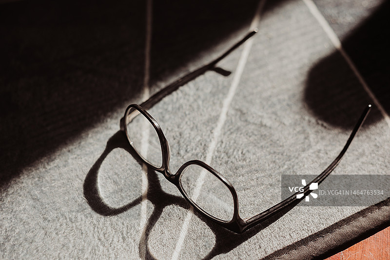 家中桌子上带阴影的眼镜图片素材