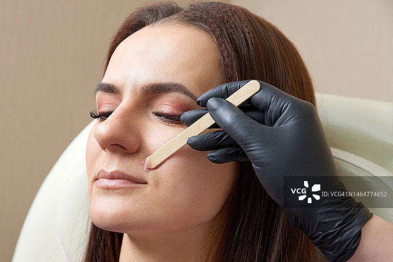 美容师为年轻女子脱去上唇的毛发图片素材