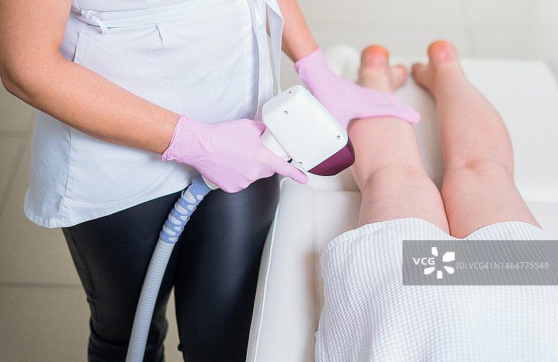 在专业美容诊所接受激光脱毛的女人图片素材