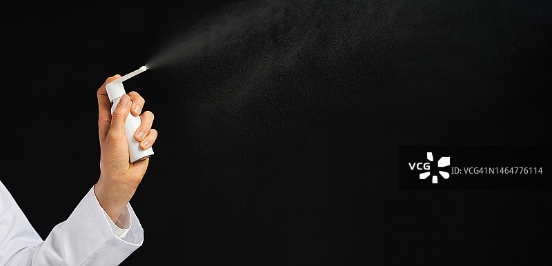 女性的手在黑色背景上使用喷雾图片素材
