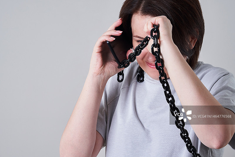 女人用锁链手机通话，沉迷手机图片素材