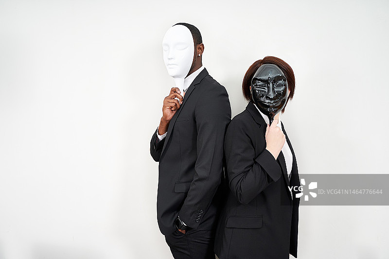 身穿黑色西装遮住脸的非洲男子和白人女子图片素材