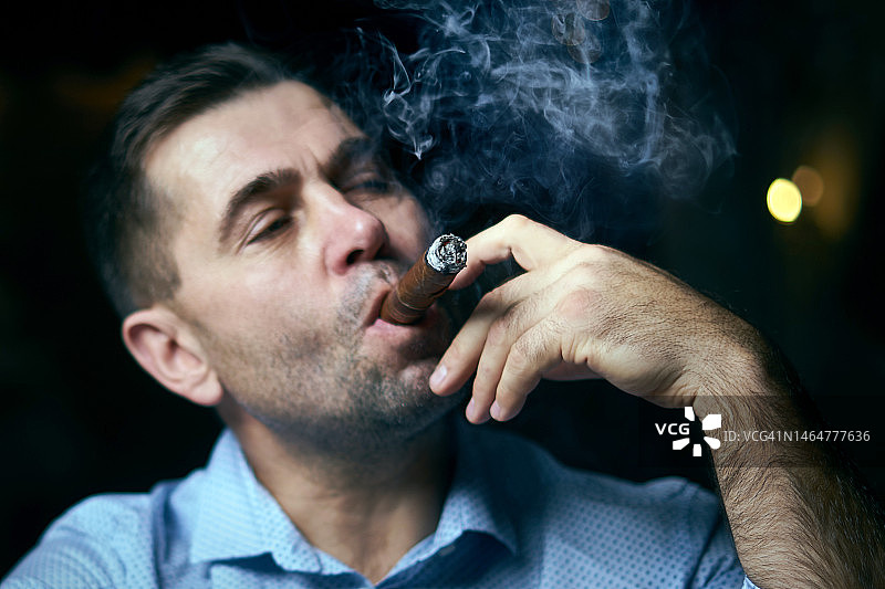在休息室酒吧抽雪茄的英俊男人 портрет图片素材